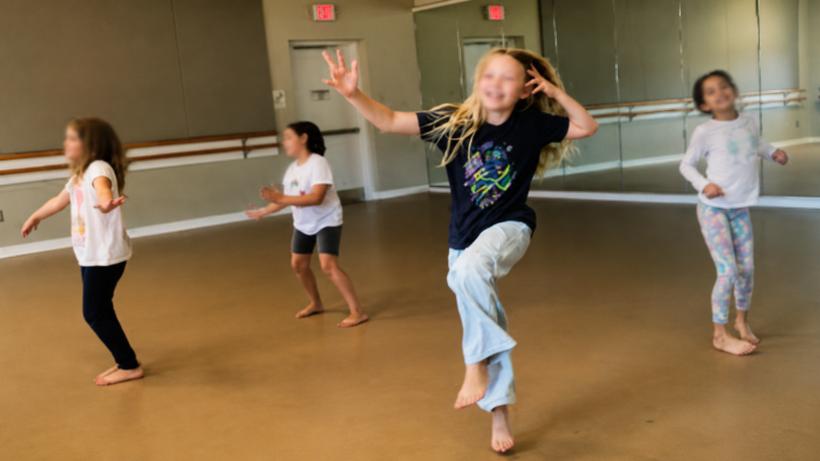Children dancing joyfully in a sunlit studio
