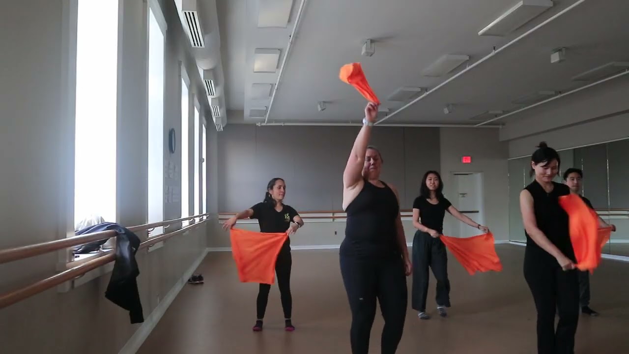 A Dancefulness class moving together with colorful scarves