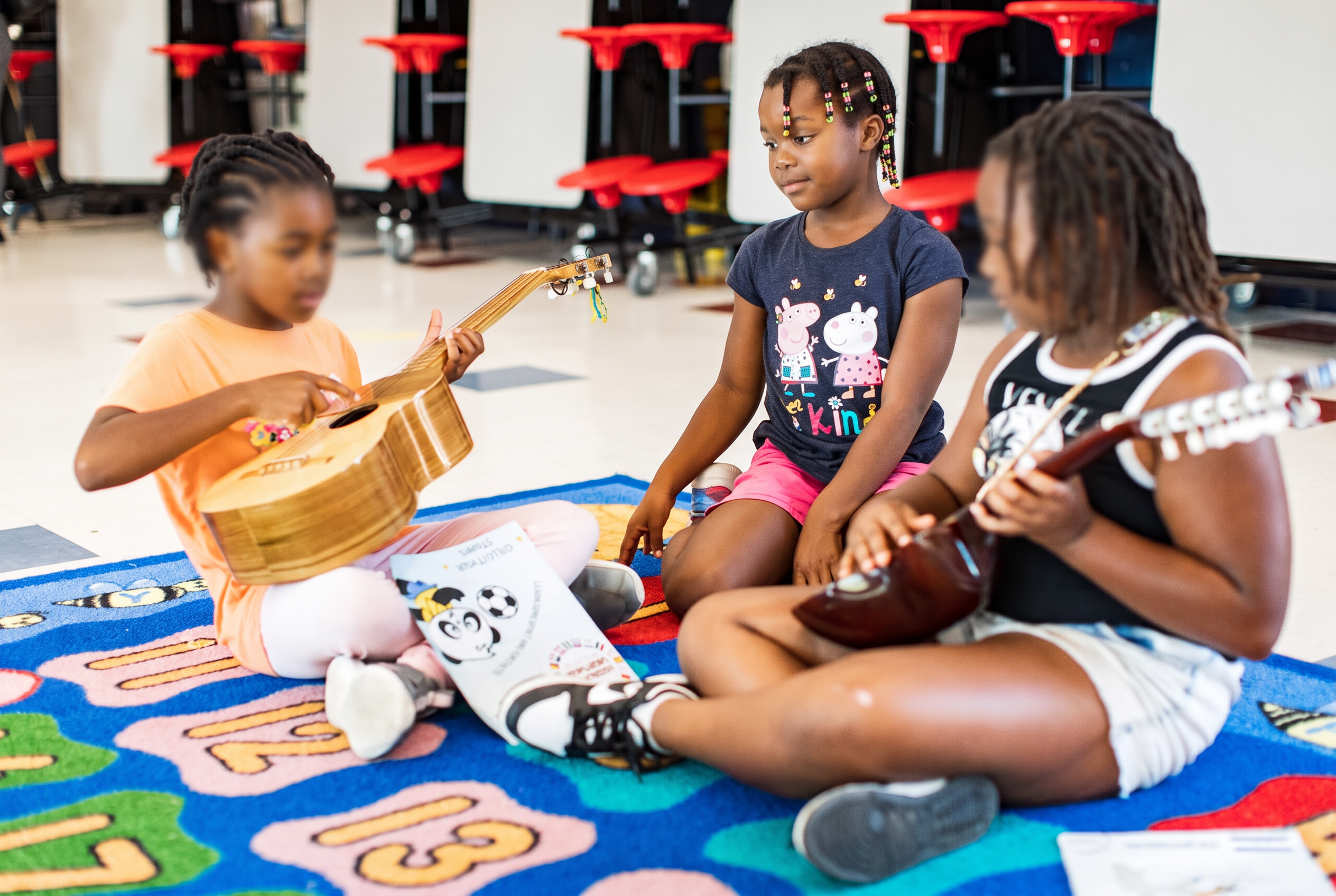 Children exploring string instruments together during a music workshop